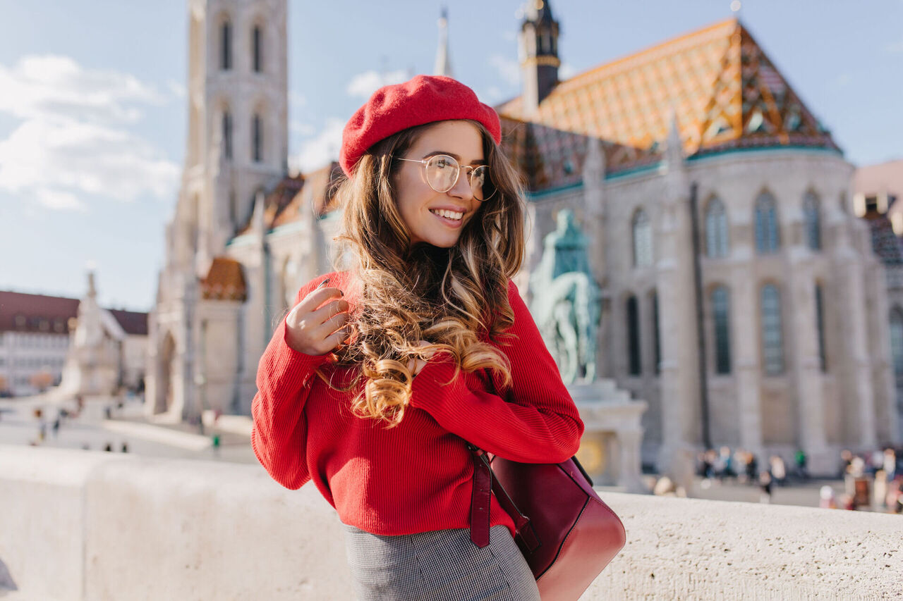 graceful-girl-red-outfit-looking-away-with-smile-visiting-old-european-castle.jpg